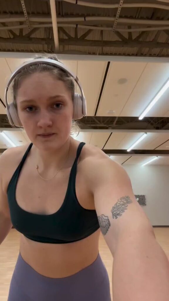 ヘッドホンをつけたジムウェア姿の女性