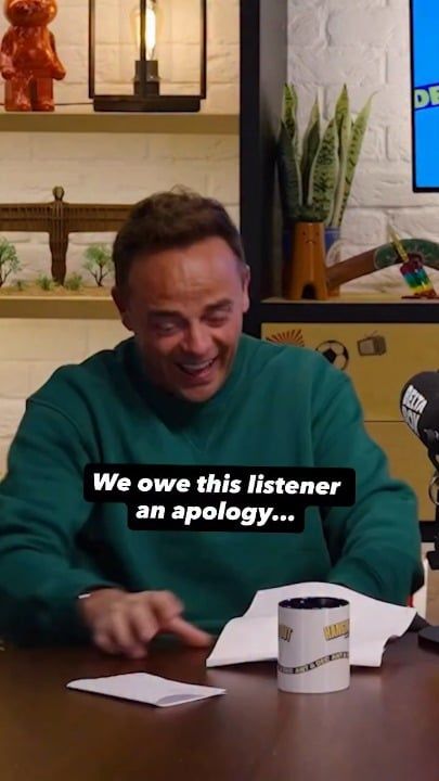 机で紙を見て笑う緑のセーターの男性