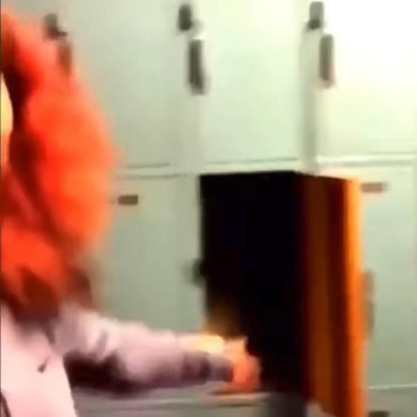 オレンジ髪の人物が光るロッカーを開ける