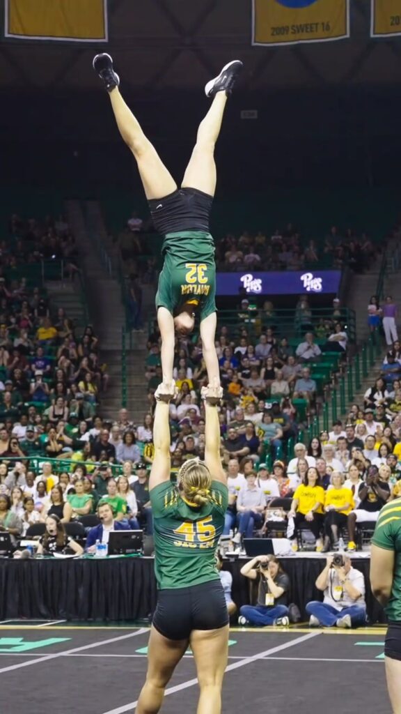 倒立する選手を支えるアクロバット演技