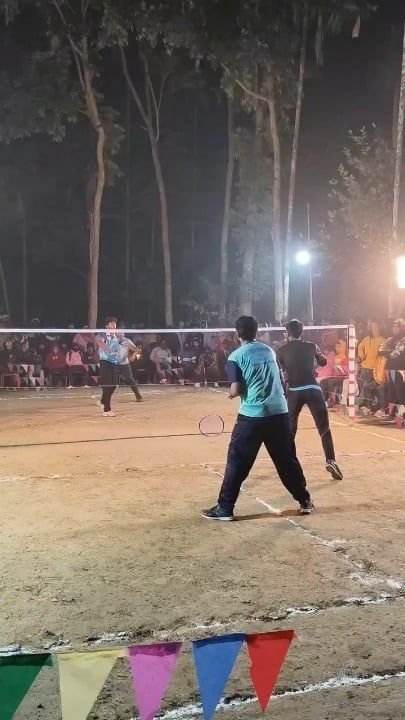 夜の屋外で行われるバドミントンの試合