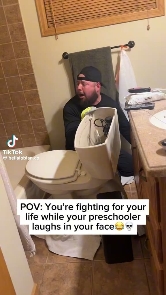 トイレの修理に苦戦している男性