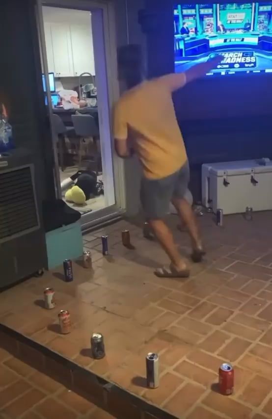 空き缶が並ぶ床で男性が飛び跳ねている