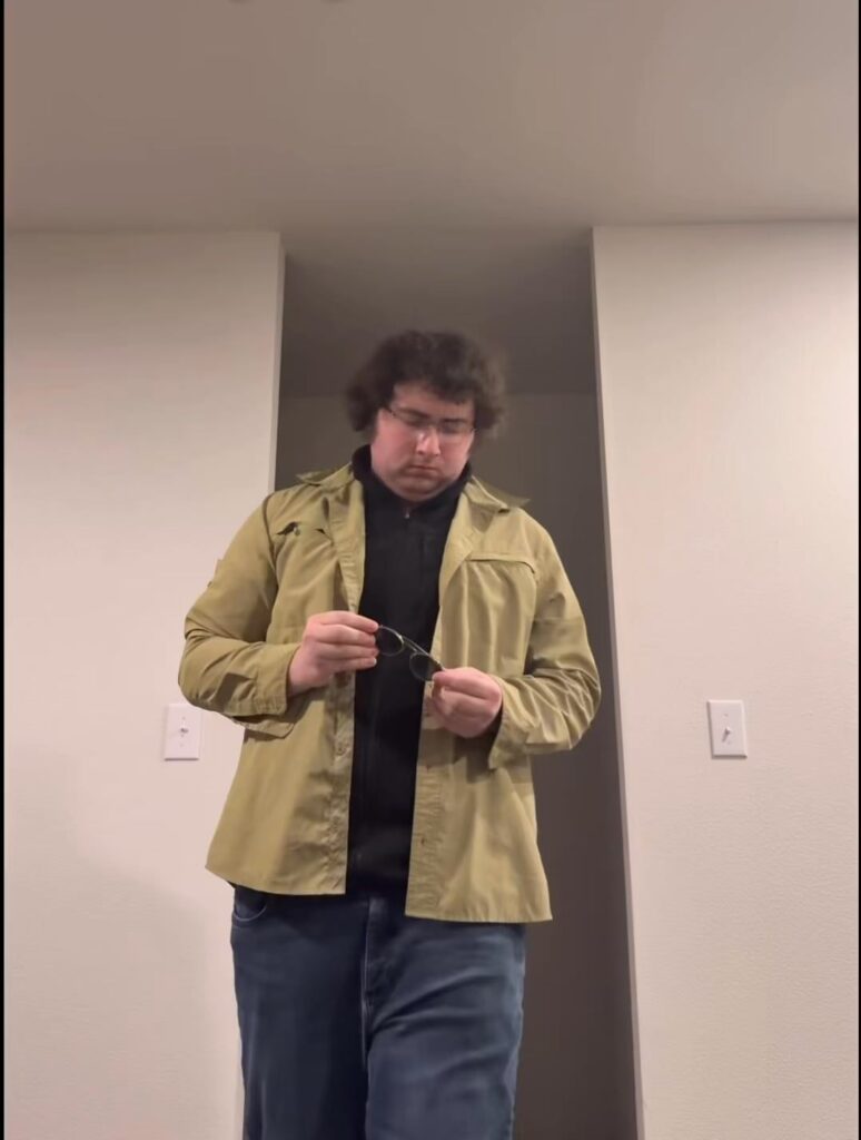 眼鏡を手に持ち下を向く男性