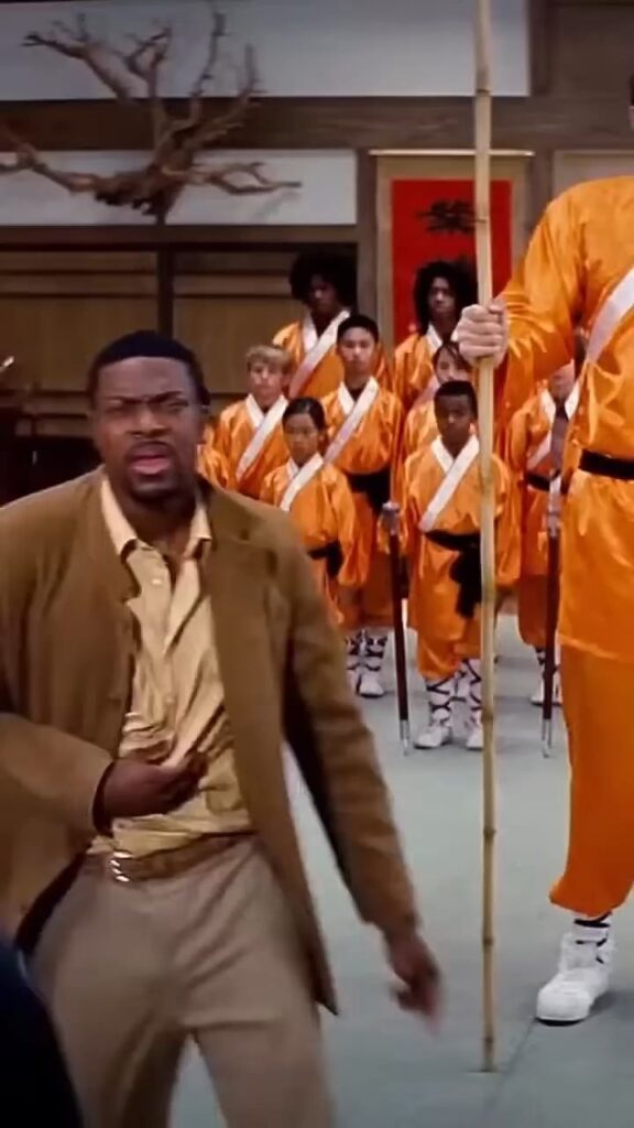 道場で困惑する男とオレンジ色の道着の集団