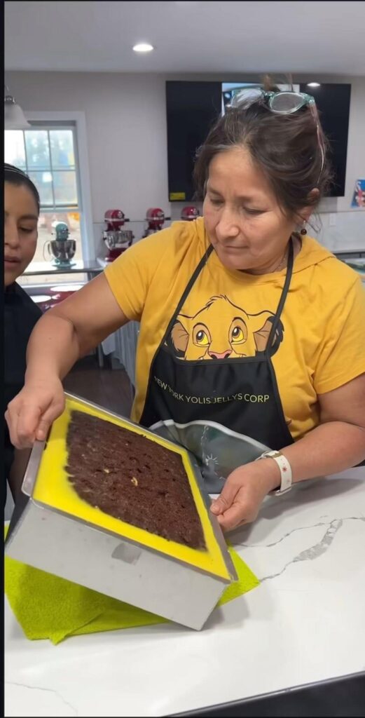 ケーキの入った型を傾けて持つ女性