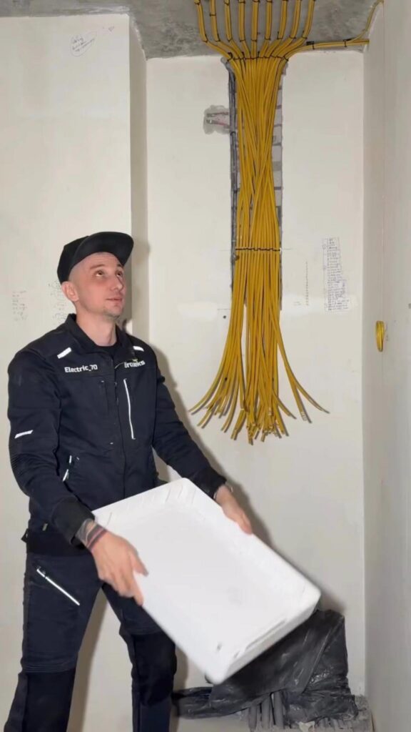 黄色い配線束を見上げる電気工事士