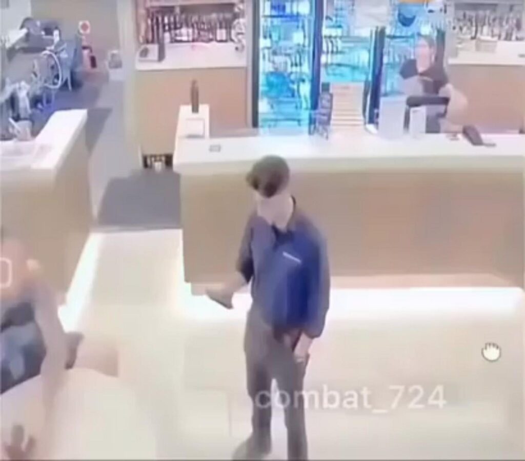 店内のカウンターの前に立つ青い服の男性