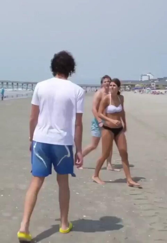 砂浜で向き合っている3人の男女