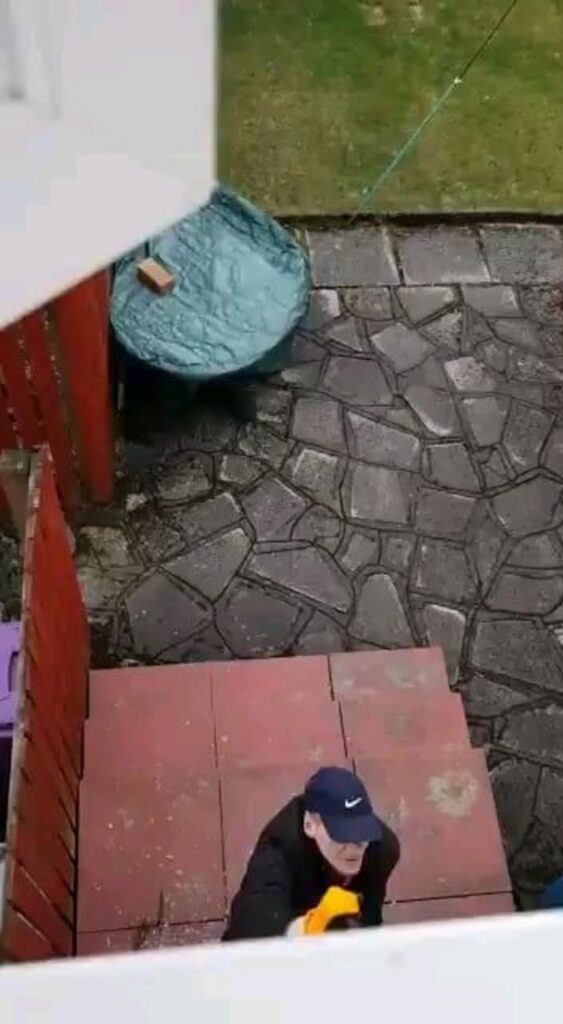 階段を上がる青い帽子の男性と石畳の庭