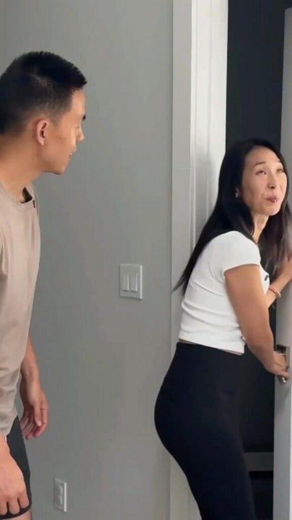 ドアを開ける女性とそれを見守る男性