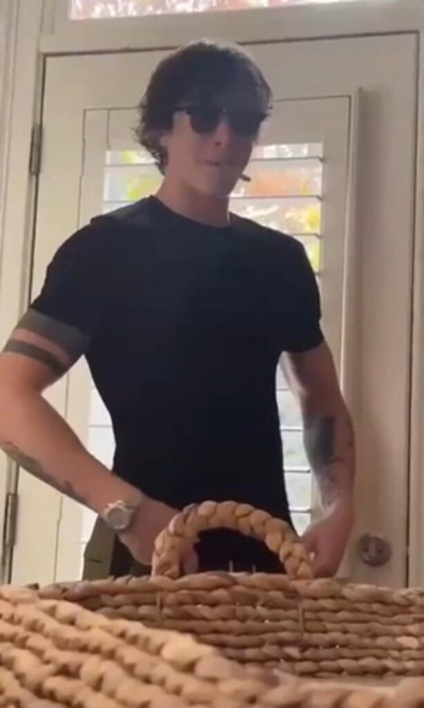 編み籠の前に立つサングラスの男性