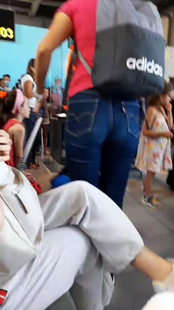 アディダスのリュックを背負う赤い服の女性