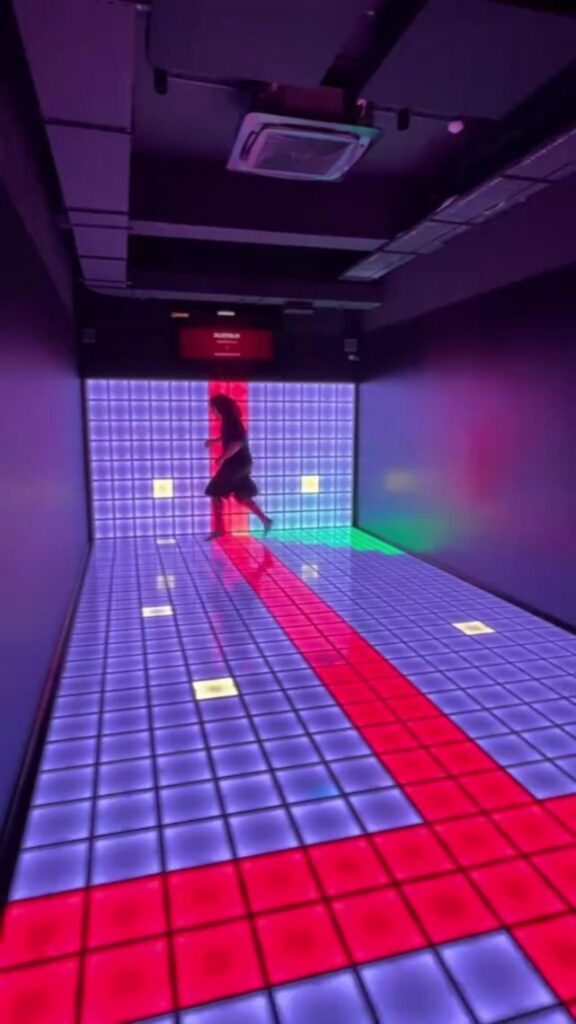 光るパネルの上を走って遊ぶ人