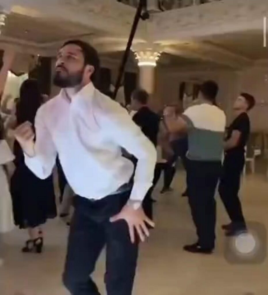 激しく踊る白いシャツの男性