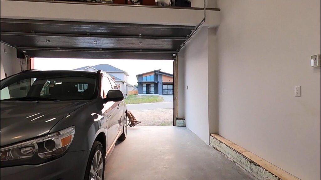 開いたガレージに停車中のグレーの車