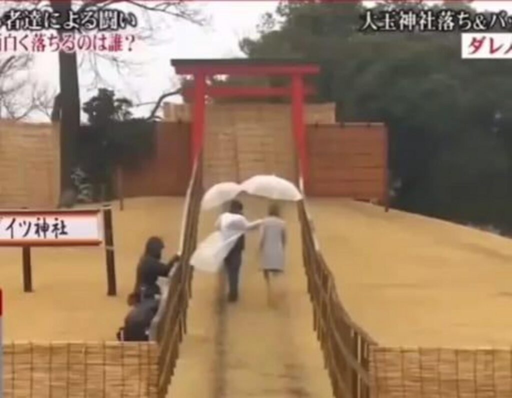 テレビ番組で白い傘を差し橋を渡る男女