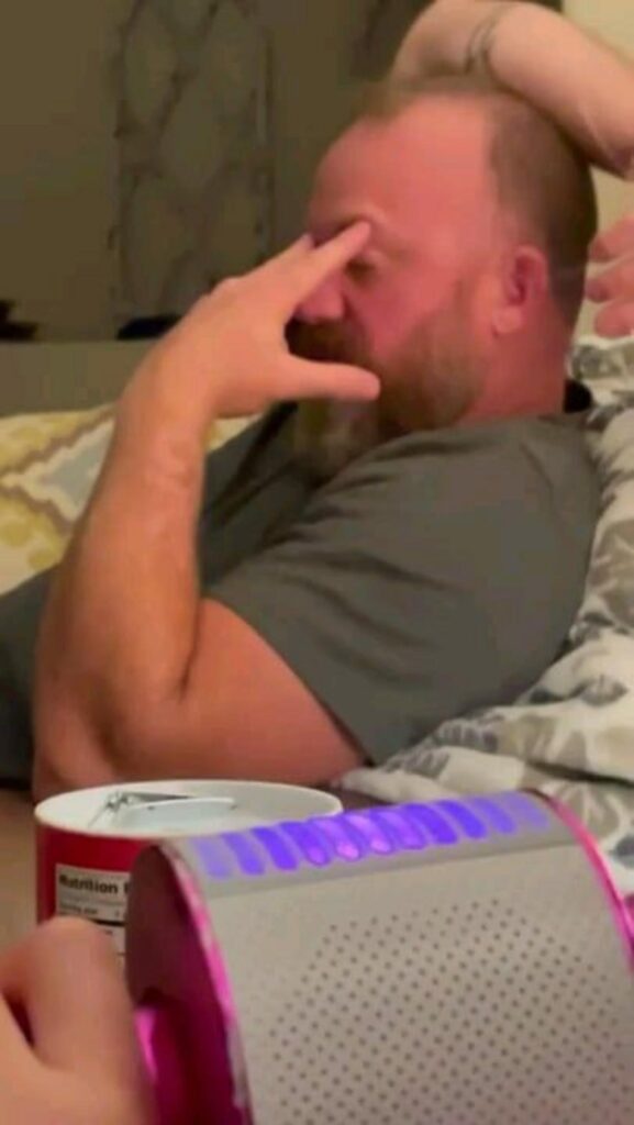 疲れて額に手を当てて座っている男性