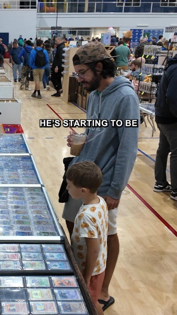 カードの展示を見る男性と男の子