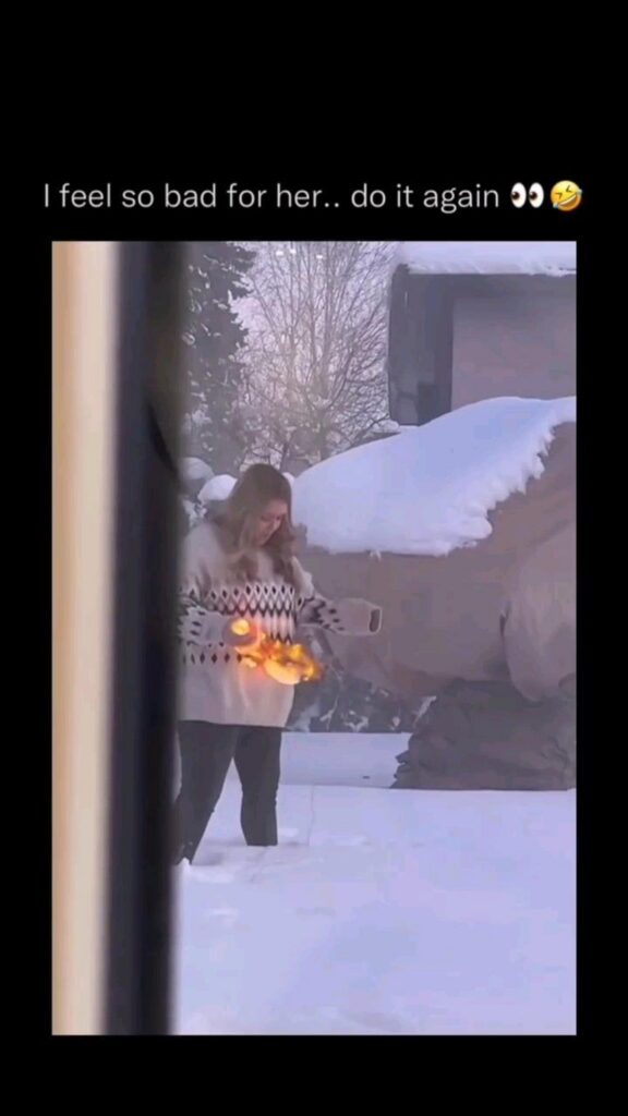雪の中で燃える食べ物の皿を持つ女性