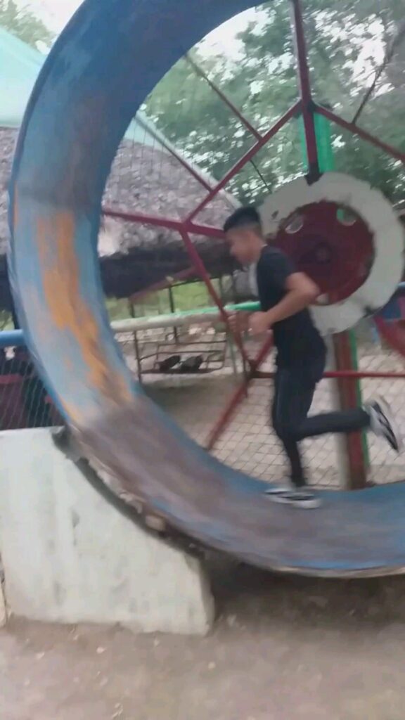 巨大な回し車の中を走る男性