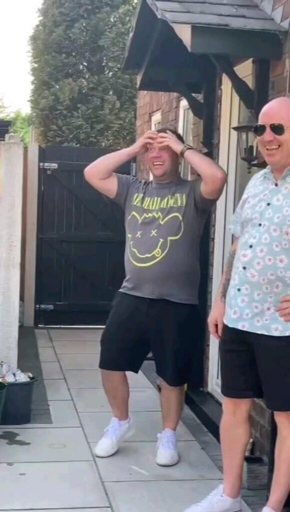 頭を抱えて驚く男性と隣で笑う男性