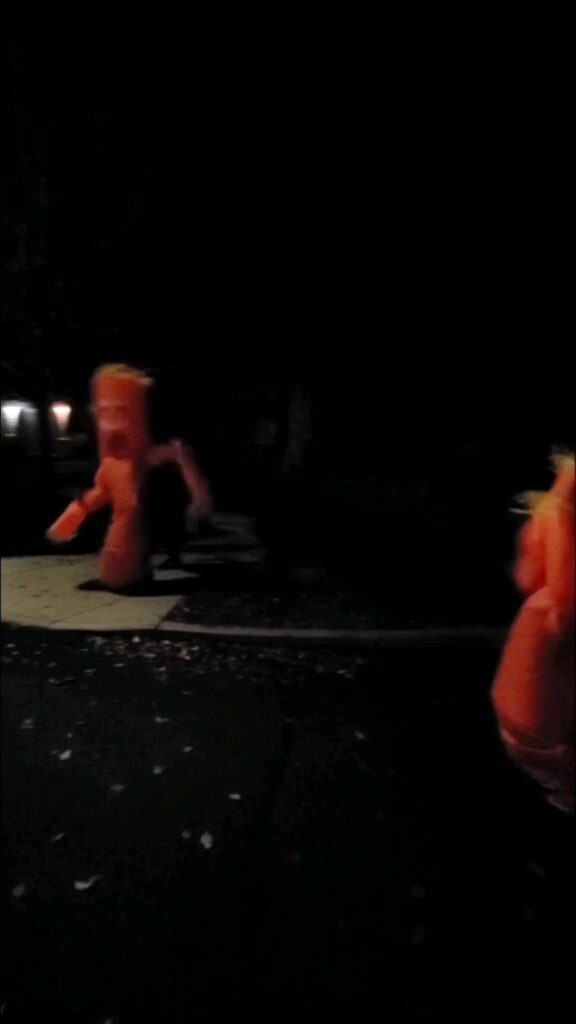 夜の屋外にあるオレンジ色の空気人形