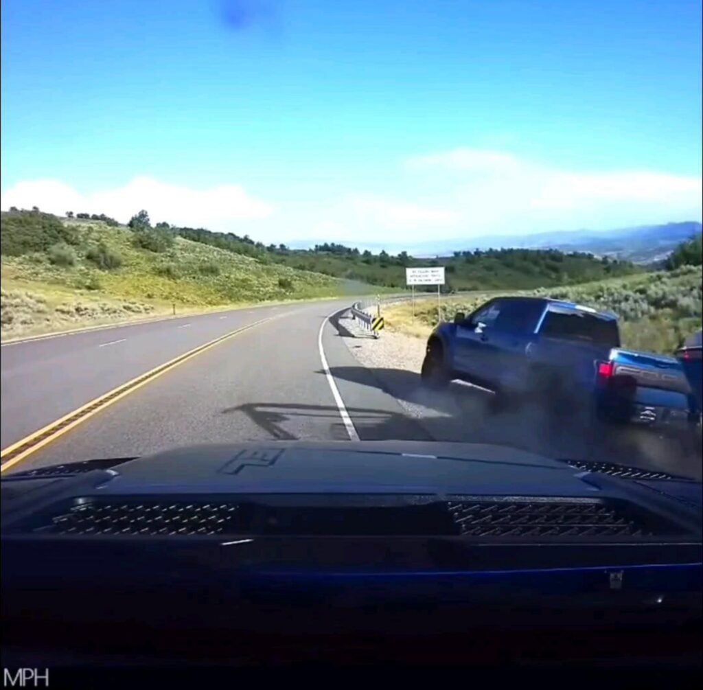 道路から外れ砂煙を上げる青いトラック