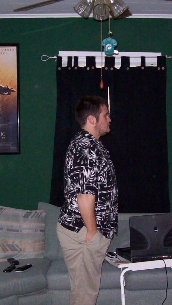 アロハシャツを着て部屋に立つ男性