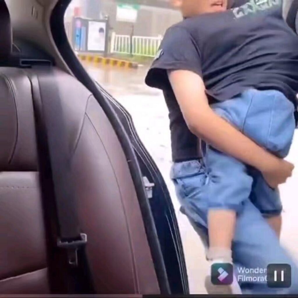 人を抱きかかえて車に乗せる様子