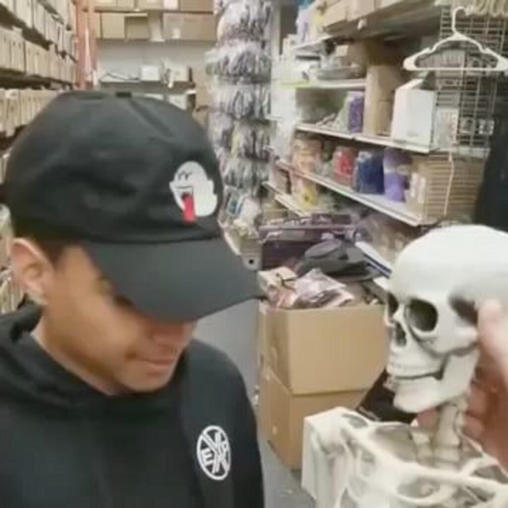 ガイコツを見つめる帽子を被った男性