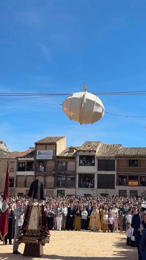 空に浮かぶ白い球体と広場に集まる群衆