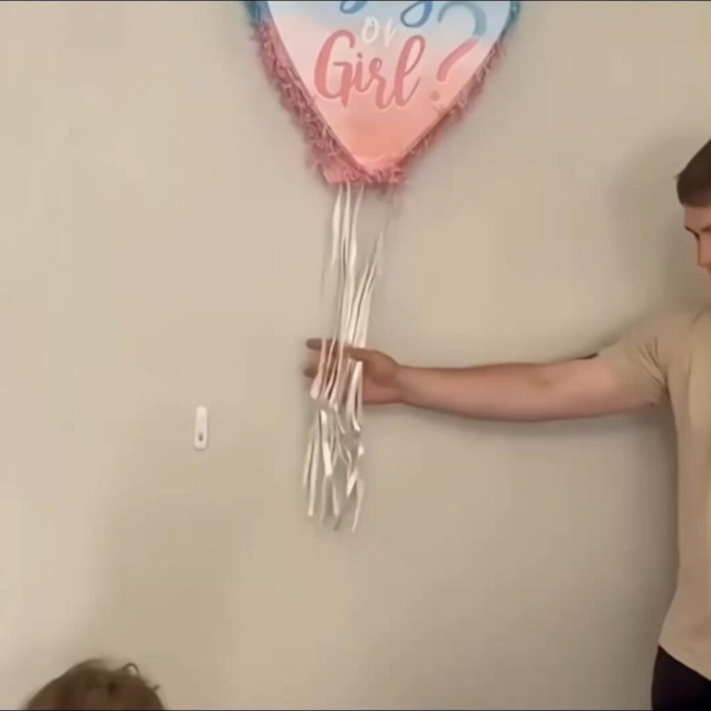 性別発表のくす玉の紐を引く男性