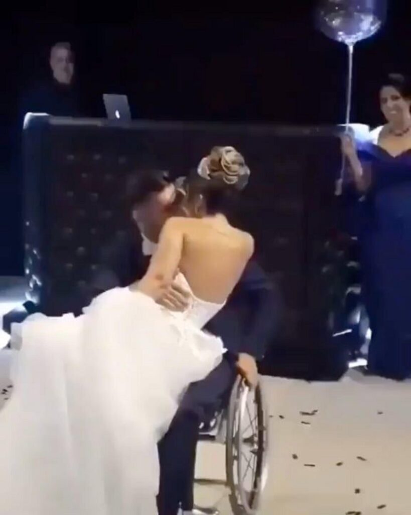 車椅子の新郎と膝に乗る新婦の結婚式