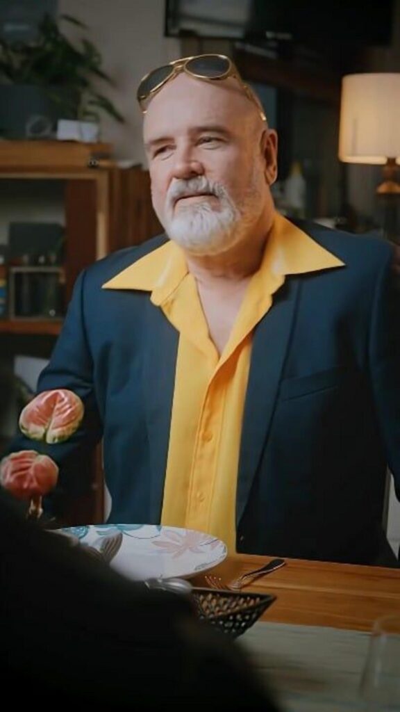 黄色いシャツを着た男性が食卓に座る姿