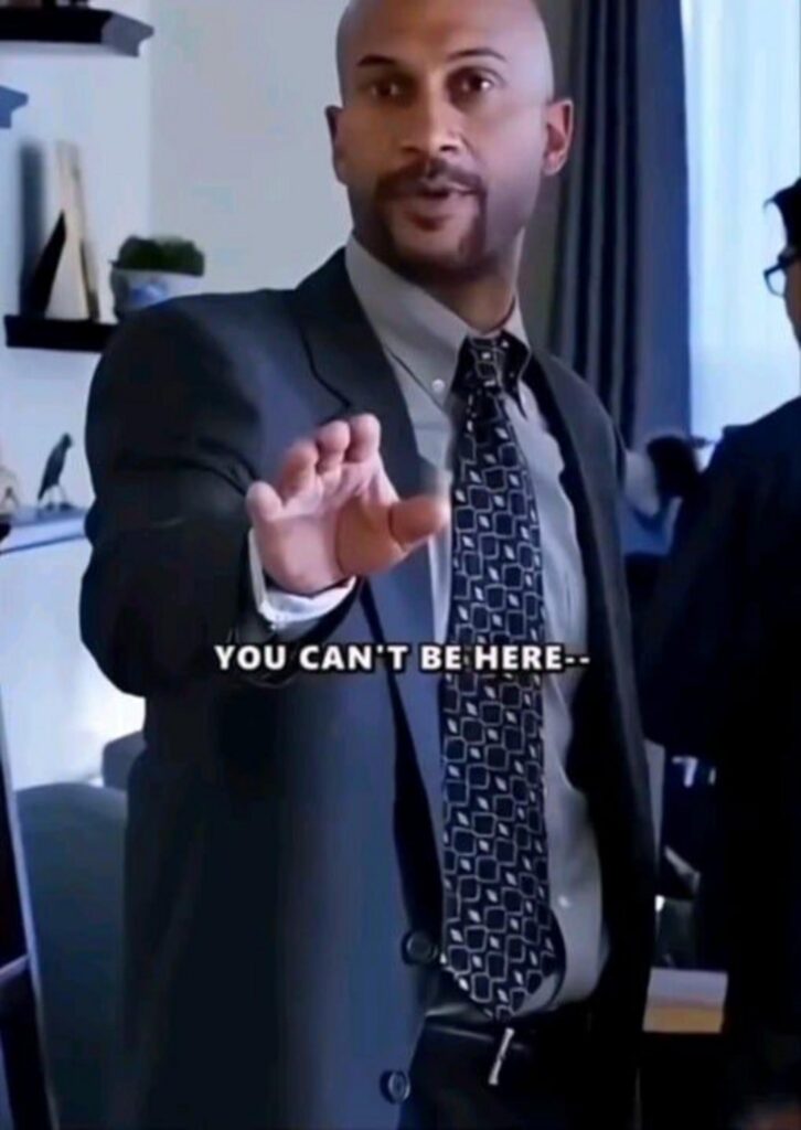 こちらを制止するスーツ姿の男性