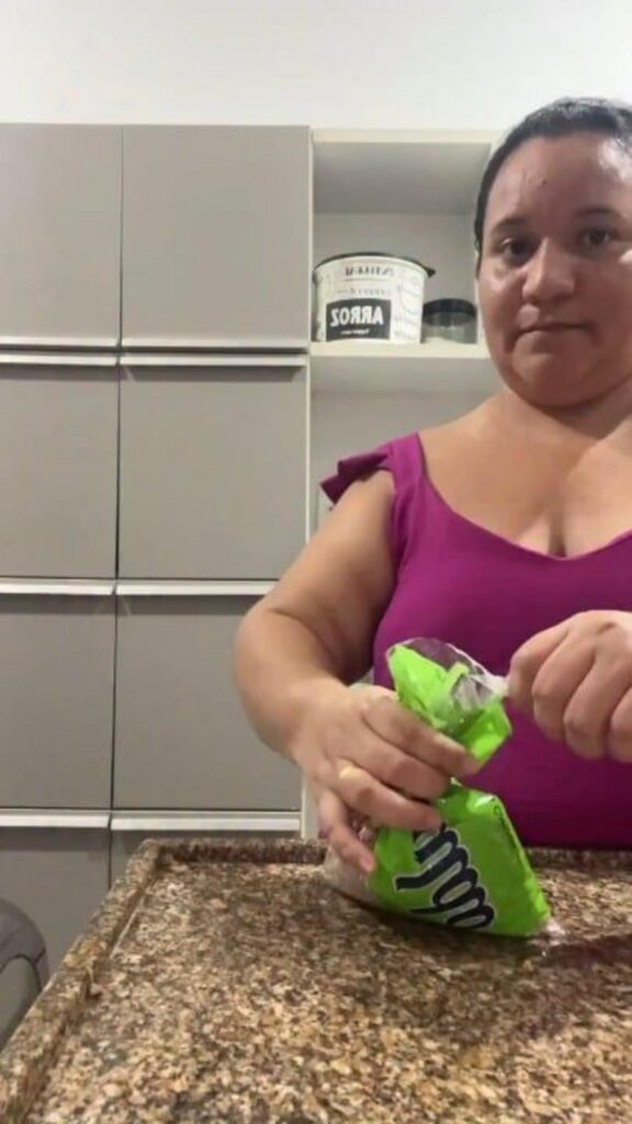 台所で緑の袋を開けている女性