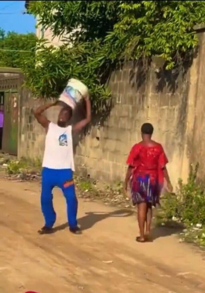 バケツを頭上に掲げる男性と歩く女性