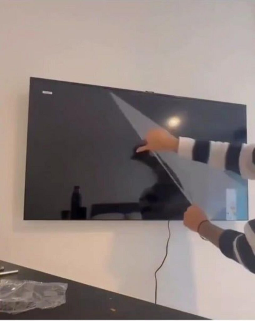 テレビの保護フィルムを剥がす様子