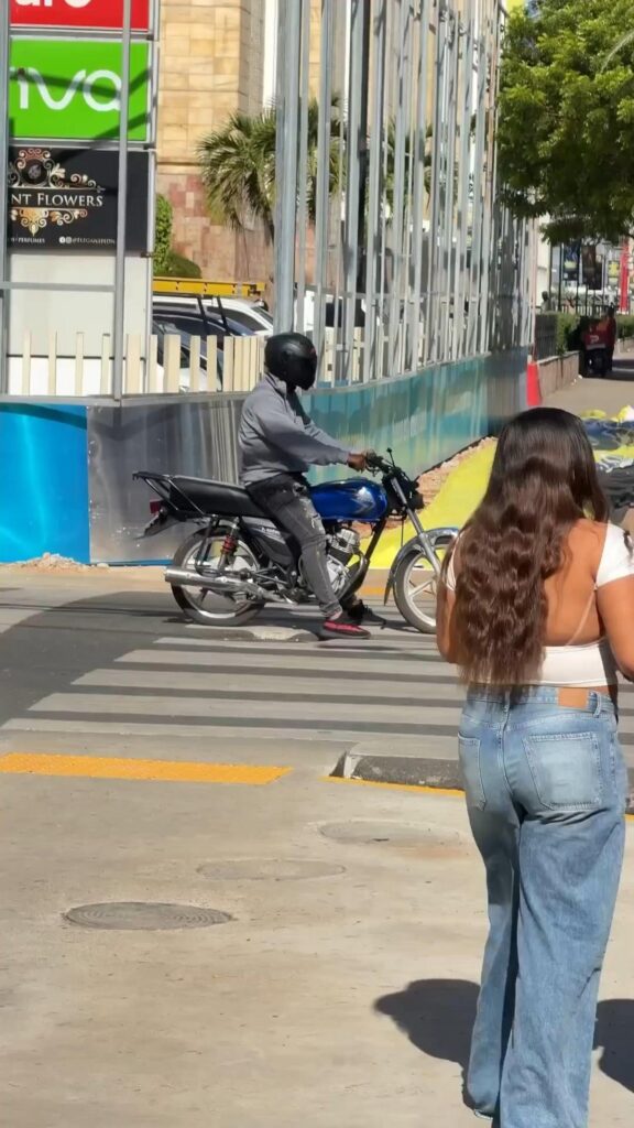 横断歩道を渡るバイクと歩く女性