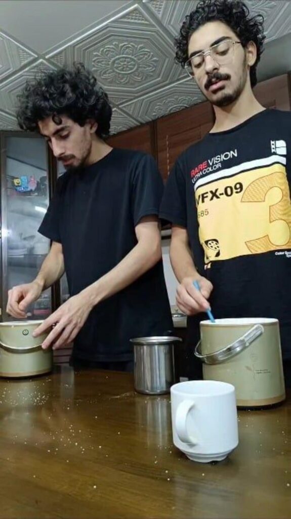 台所で飲み物を準備する二人の男性